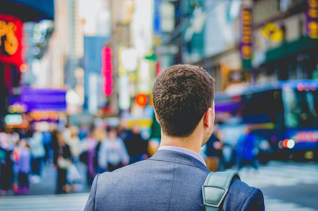 a man in a suit staring onto a busy street