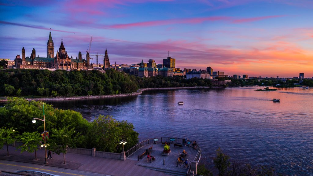 View of the Ottawa river during a sunset with Parliament Hill in the background.