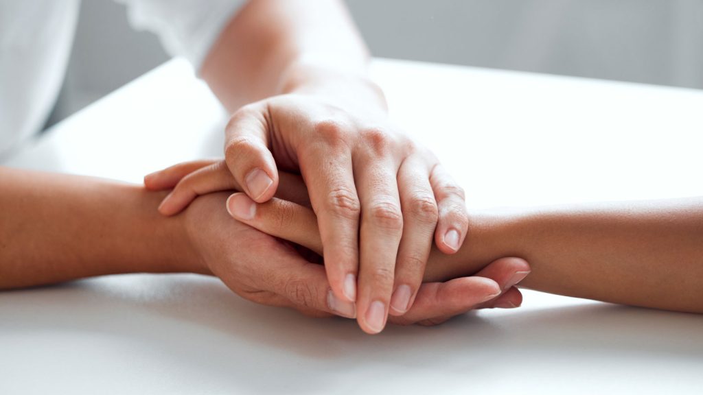 Two individuals holding hands