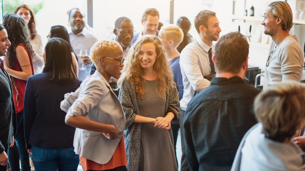 Group of professionals in a networking setting, looking pleasant and engaged with one another
