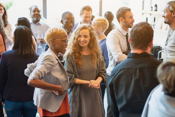 Group of professionals in a networking setting, looking pleasant and engaged with one another